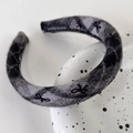 Macro shot of grey plaid knit headband featuring black bow patterns and handmade label tag - Grey Black Striped Bow Style