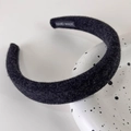 Close-up of thick black plush headband with hand made label and fuzzy wool texture - Black Woolen Style