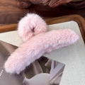 Close-up of a pink plush shark hair claw clip on a wooden tray with soft faux fur texture - Pink