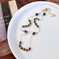 Detail of tiger eye stone beads and gold spacers on a layered necklace for women - Flat Beaded Necklace Style (26131)