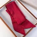 Close-up of a dark red satin skinny scarf with pointed ends on a wooden display tray - Red (26183B)