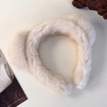 Gros plan d'un serre-tête en peluche beige doux avec une texture moelleuse pour l'hiver - Beige