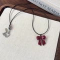 Détail macro du pendentif nœud rouge sur cordon noir avec étiquette argent S925 - Large Noeud
