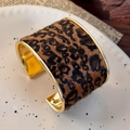 Close-up of wide leopard print open bangle with gold polished metal edges and fuzzy texture - Fine Leopard (26187E)