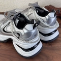 Detail of silver metallic sneakers featuring double pearl chains and silver metal links - White