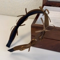 Detail of dark brown satin headband featuring multiple small delicate bows on a white surface - Coffee Style (26268A)