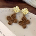 Nahaufnahme der Vintage-Blumenohrringe mit goldenem Metall und braunen Samtblüten - Kaffee Blume