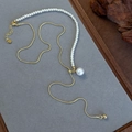 Detail view of adjustable pearl and gold snake chain necklace on a display board - Golden Asymmetric Pearl Splicing Style (26164A)
