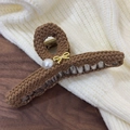 Detalle de la pinza para el pelo de lana marrón con lazo dorado y perla blanca - Café Oscuro