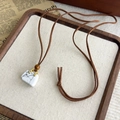 Détail du collier vintage en cordon de velours avec pendentif sac en marbre blanc - Blanc pur