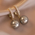 Detail shot of micro-pave zircon gold earrings with elegant dark grey pearl drops on silk - Silver Gray