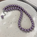 Macro di una collana di perle di vetro viola scuro con chiusura a moschettone in argento - Collana con Perle Rotonde da 10mm (26300E)