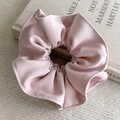 Macro shot of light pink layered fabric scrunchie with pleated twill texture - Pink