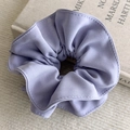Detailed macro view of purple oversized fabric scrunchie with layered pleated texture - Purple