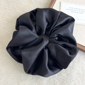 Detailed close-up of a large black satin scrunchie showing smooth silk texture and shine - Black