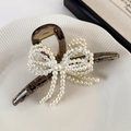 Close-up of pearl bow hair claw with elegant crystal accents and hanging tassels - Gray (25153A)