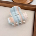 Vue détaillée d'une pince à cheveux en acétate avec des rayures bleues et beige sur un plateau - Rose Bleu Mixte