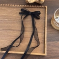 Détail d'une pince à cheveux vintage avec nœud en dentelle noire et longs rubans - Nœud Noir