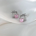 Macro shot of pink resin butterfly earrings with star and flower crystal details on silk - Pink Butterfly