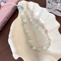Dettaglio del laccetto per cellulare con perle crema e ciondoli a stella marina su conchiglia - Perla Artificiale Bianca Conchiglia (25333A)