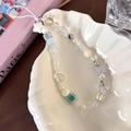 Dettaglio di un ciondolo per telefono con perline, conchiglia e farfalla in piatto - Farfalla Colorata (25333D)