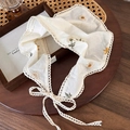 Detail van witte katoenen kanten hoofddoek met geborduurde madeliefjes en textuurranden - Driehoekige Hoofddoek