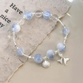 Close-up of beaded bracelet with light blue crackle beads and silver fish tail shell charms - Blue Shell Fish Tail (25368A)