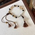 Bracciale etnico con perline, ciondoli a stella e cordino con nappe regolabile - Brown And Beige