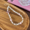 Nahaufnahme der rosa Herz-Handykette mit weißen Perlen auf einem Holztablett - Rosa Herzperlen-Stil (25373C)