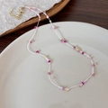 Dettaglio della collana di perline colorate con stelle e fiori su piatto bianco e chiusura - Stile Perline Corda Rosa (23212)