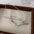 Detaillierte Nahaufnahme eines silbernen Schleifen-Chokers auf einem beigen Schmucktablett - Silber (25430B)