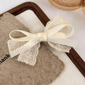 Vintage beige Spitze Stickerei Haarklammer mit Satinband auf rustikalem Hintergrund - Creme