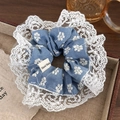 Dettaglio dell'elastico in denim blu con ricami floreali, pizzo bianco e etichetta fatta a mano - Blu Chiaro