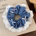 Close-up of denim hair scrunchie with white lace trim and colorful satin ribbon bows - Light Blue (25492A Light Style)