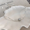 Detail of square silver beads and a gray pearl in a shell-shaped tray with a heart charm - Silver Gray Pearl
