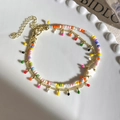 Detailed view of double-layer beaded bracelet with colorful charms and star bead on white plate - Shell Star Style