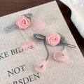 Detalle de pendientes de rosa de tela rosa con pétalos colgantes sobre fondo de lino - Flor Rosa