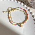 Detailaufnahme des zweilagigen Perlenarmbands mit goldener Kette und Perlenanhänger - Süßwasserperlen-Stil