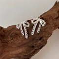 Minimalistische silberne Schleifenohrringe mit Spitzen-Hohl-Design auf Naturholz - Silber Schleifen-Stil
