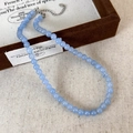 Détail du collier de perles en pierre bleu clair avec fermoir mousqueton argenté sur boîte - 6mm Collier