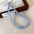 Détail macro du collier de perles bleu mer avec fermoir argenté sur un écrin à bijoux - 8mm Collier