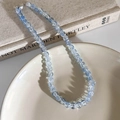 Detailansicht der hellblauen und klaren Krakelée-Glasperlen mit silbernem Metallverschluss - Buntes Blau (8mm)
