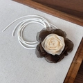 Detailopname van een stoffen camellia choker met elegante lange veters op linnen textuur - Abrikoosgrijs