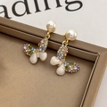 Primer plano de pendientes de mariposa con pedrería colorida, perlas y acabado dorado - Mariposa de Colores (Dorado)