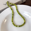 Macro view of green stone beaded necklace with silver clasp on white textured ceramic - 6mm Necklace (25664A)