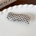 Detail of wavy resin hair clip with black polka dots on an elegant lace ceramic plate - White Base Black Dot Wave