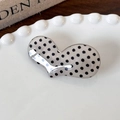 Gros plan d'une pince à cheveux en acrylique à pois avec insert métallique argenté - Base Blanche Points Noirs Cœur