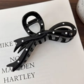 Detail view of a black hair claw clip with white polka dots and a sturdy metal spring - Black Polka Dot Style (25662B)