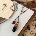 Detail der Pinienkern-Halskette mit Keramikperlen an einer schwarzen Kordel - 25683C Schwertbohnen-Stil