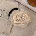Detail van champagne organza roos haarelastiekje met gouden bies en zwarte band - Beige Bloem Haarelastiek